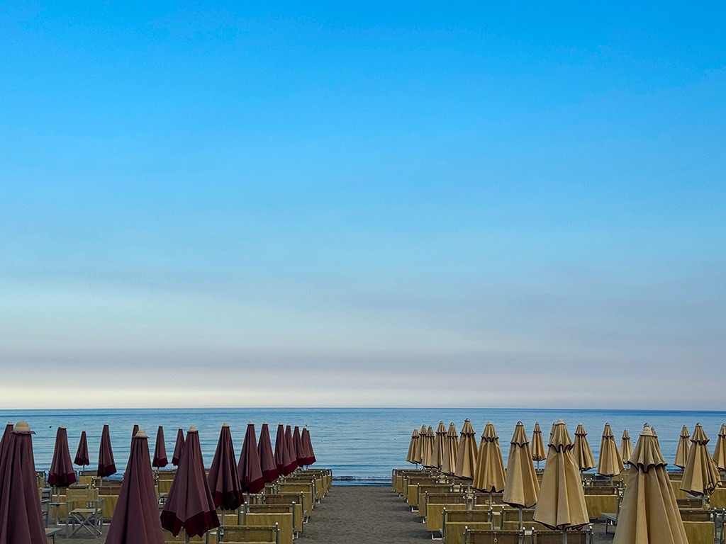 sunbeds on the beach at diano marina in liguria at sunset