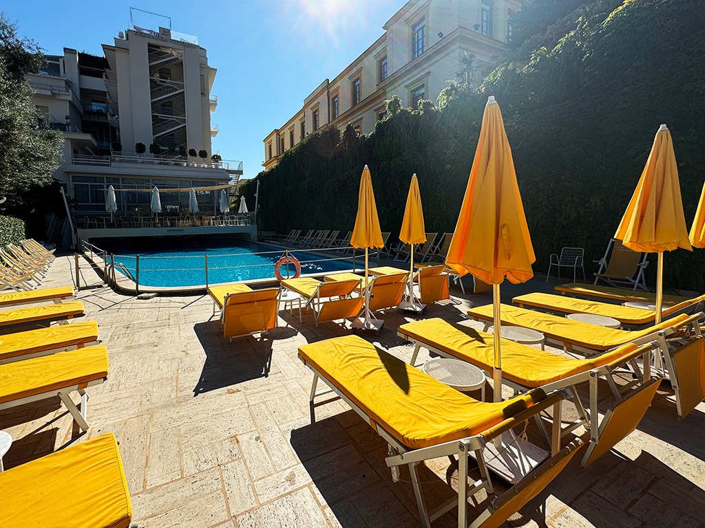 yellow sunbeds and parasols around swimming pool of hotel continental sorrento