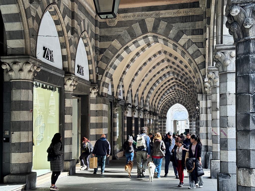 shopping portico with pointed arches and striped brickwork in genoa