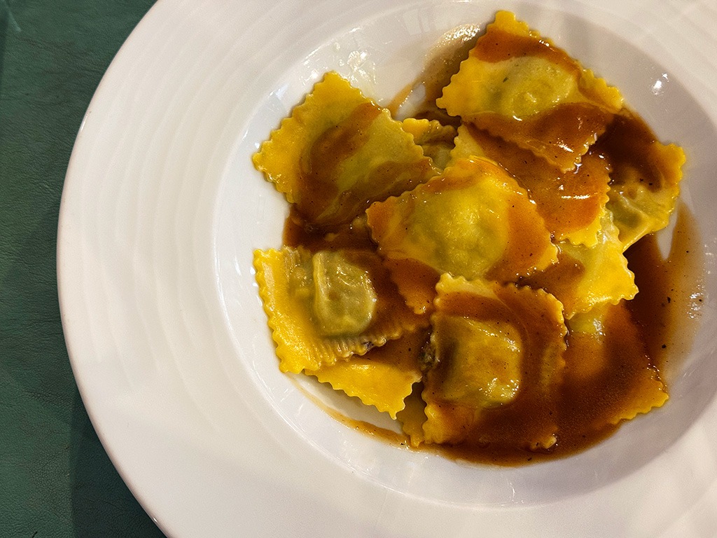 agnolotti square pasta parcels in a dark meat sauce