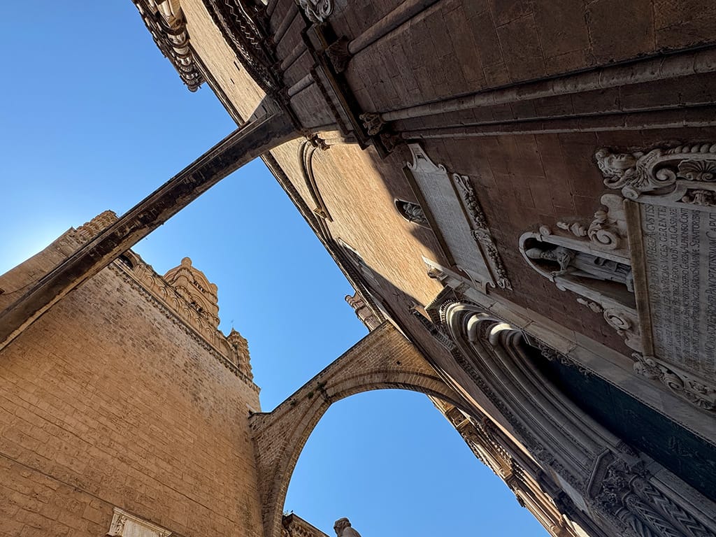 view looking up at the butresses of the cathedral with blue sky behind