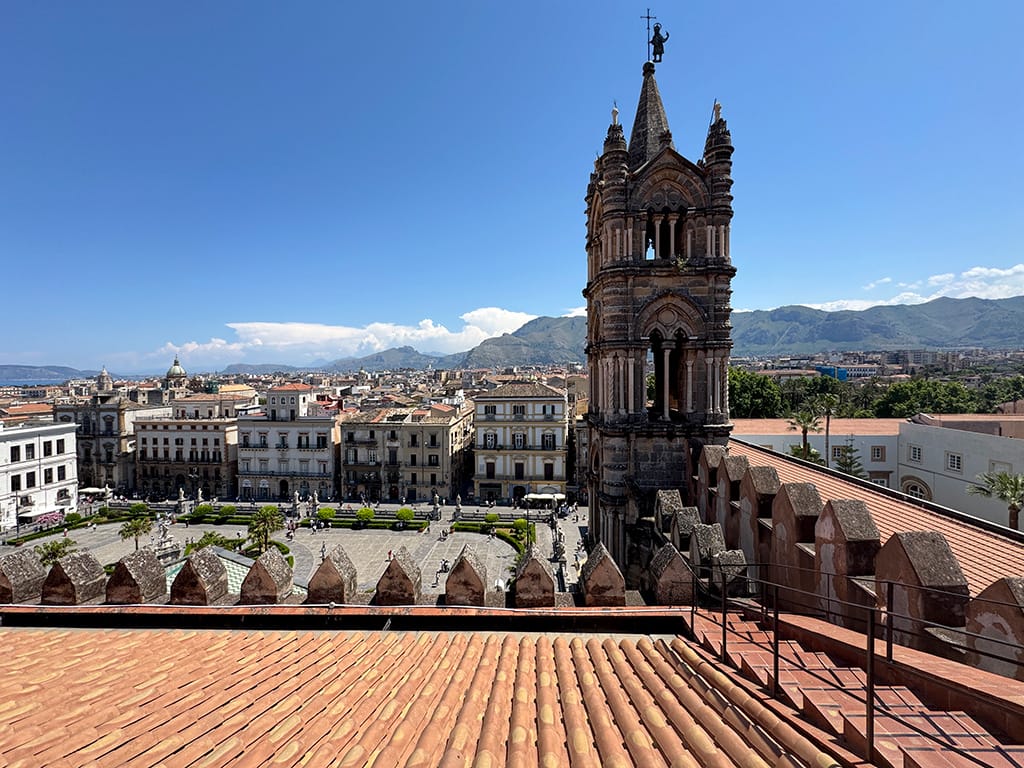 view over palermo rooftops and bell tower with mountains beyond