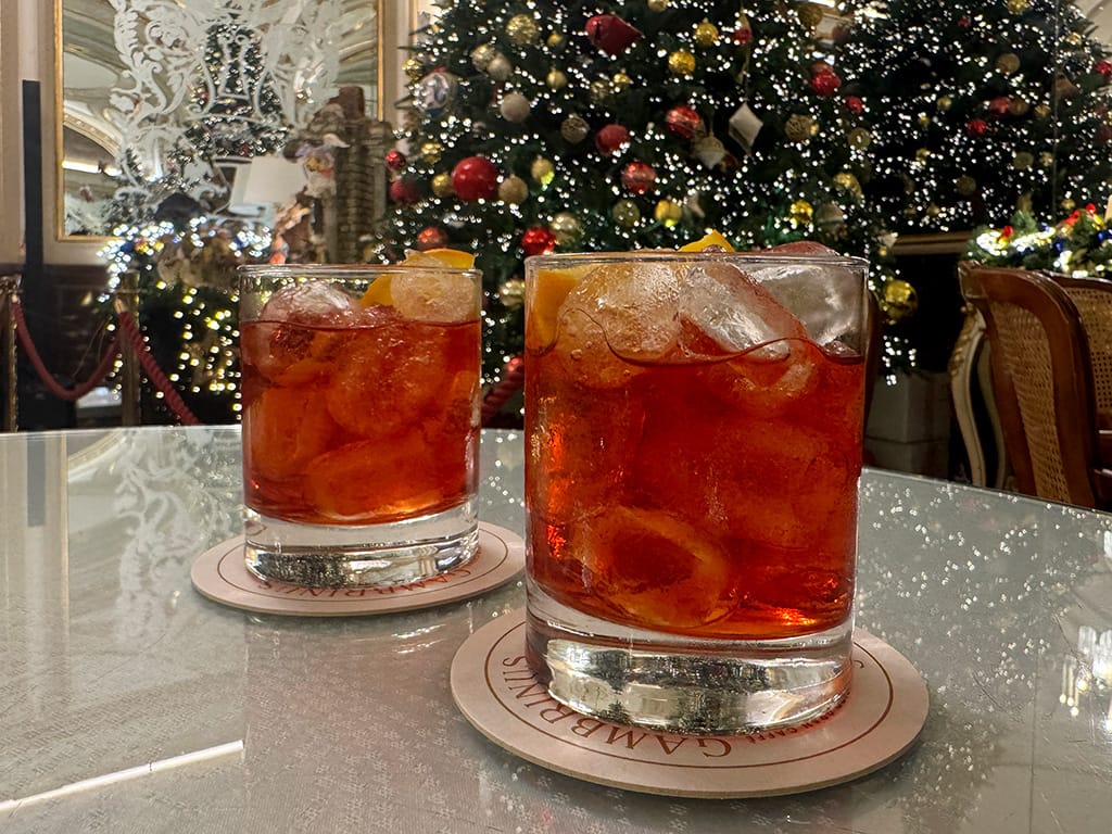 two negroni cocktails with christmas tree in the background